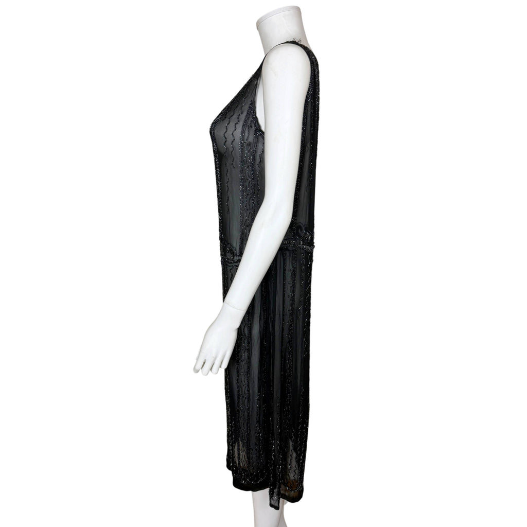 Side profile of antique 1920s black silk chiffon beaded dress showing straight silhouette and mid-calf length