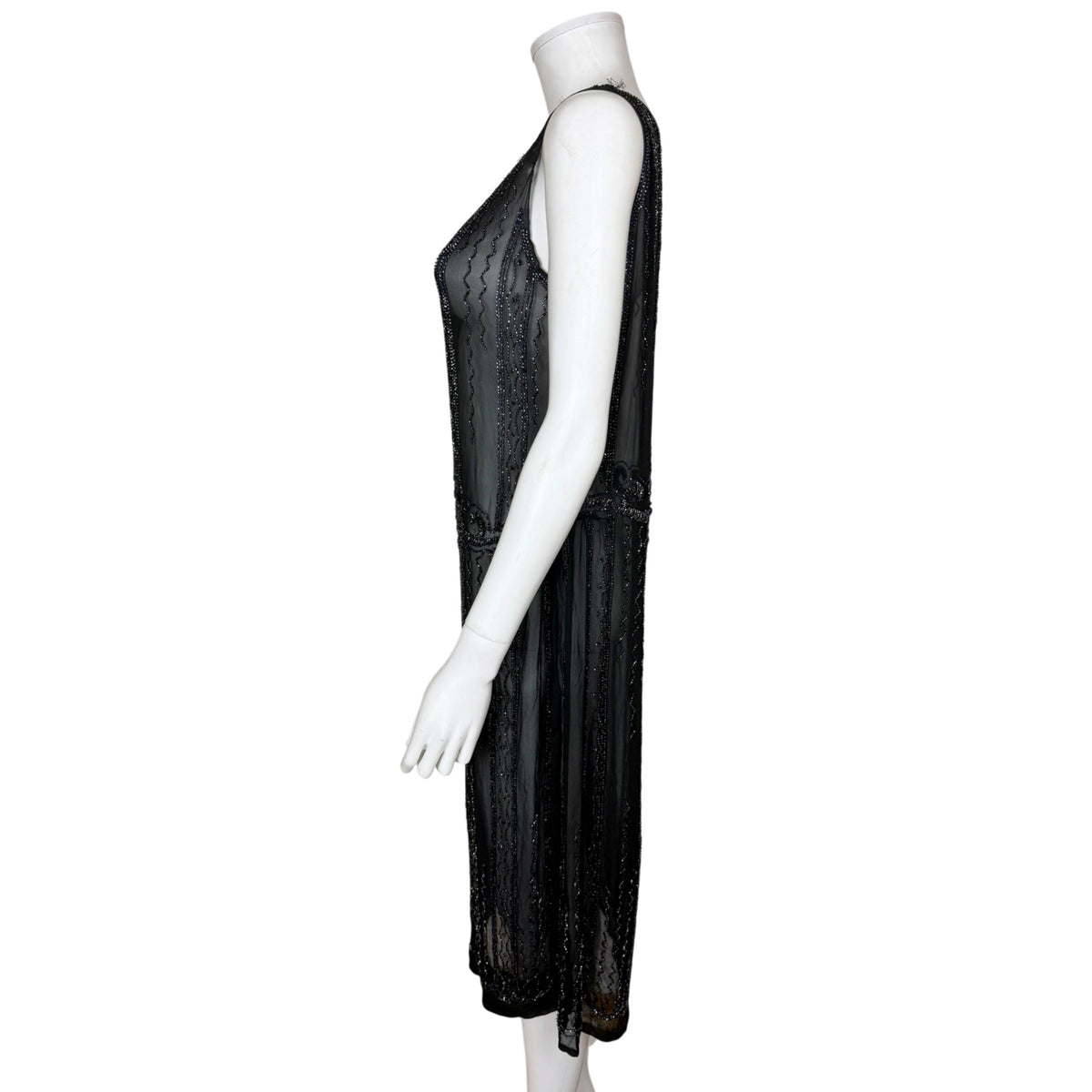 Side profile of antique 1920s black silk chiffon beaded dress showing straight silhouette and mid-calf length