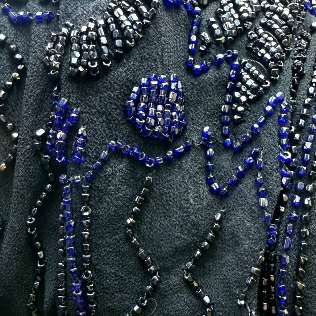 Macro detail of original 1920s glass beadwork in cobalt blue and metallic gunmetal on black silk chiffon