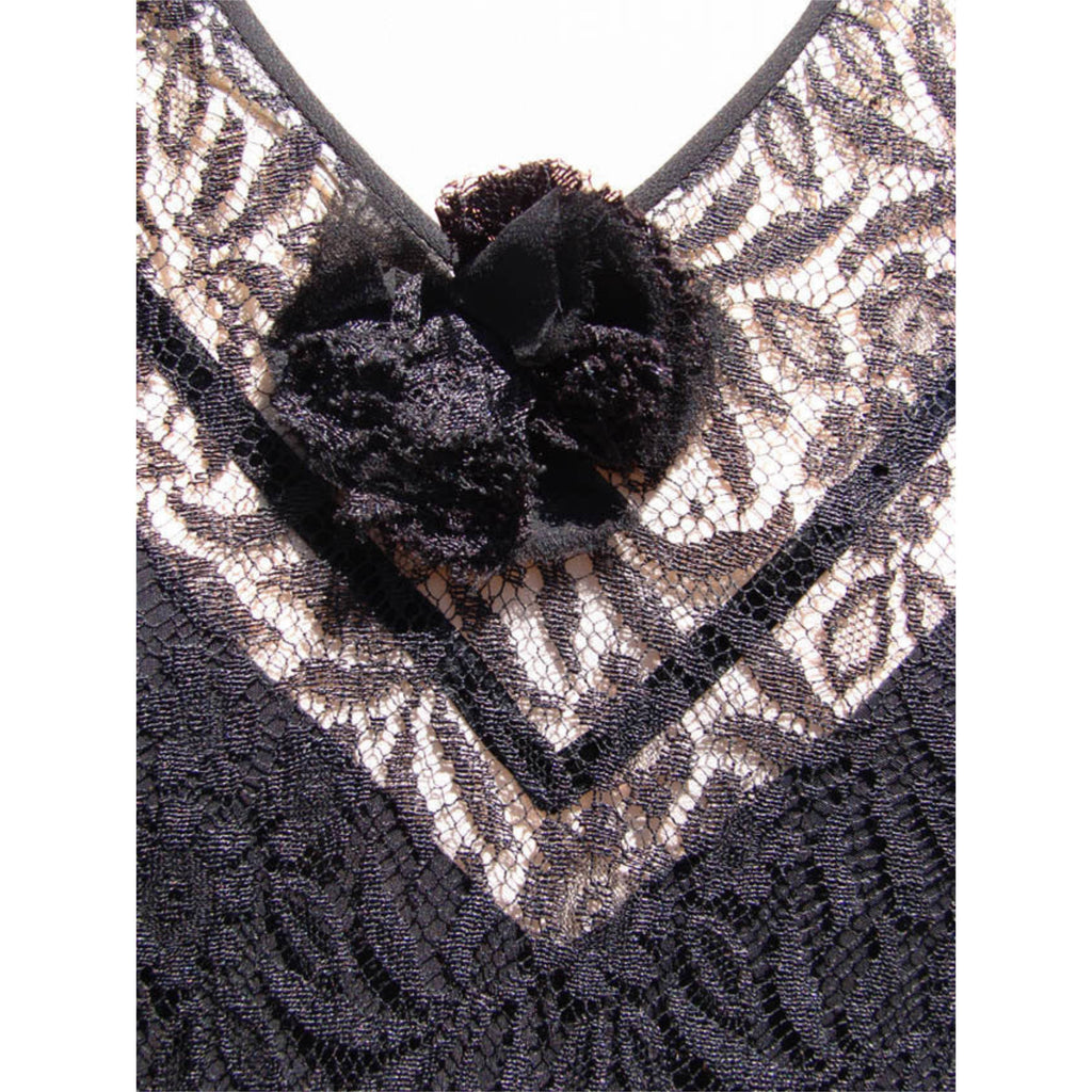 Close-up of a black lace 1930s dress with a textured floral applique at the neckline