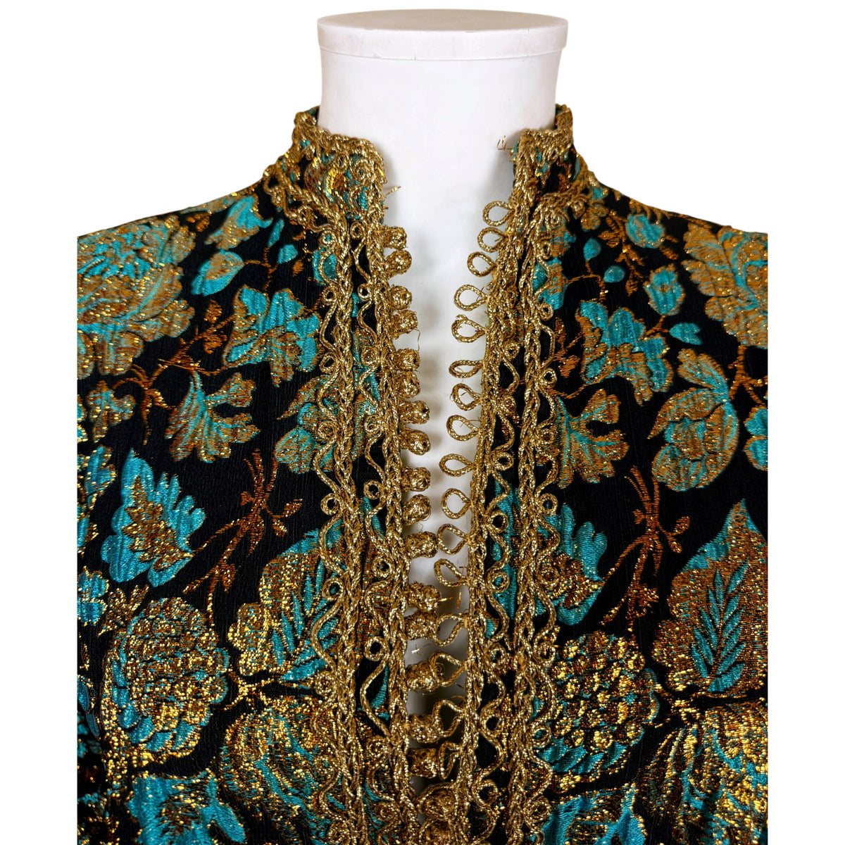 Detailed view of traditional Moroccan gold akkad knot buttons and loop closures along the kaftan neckline