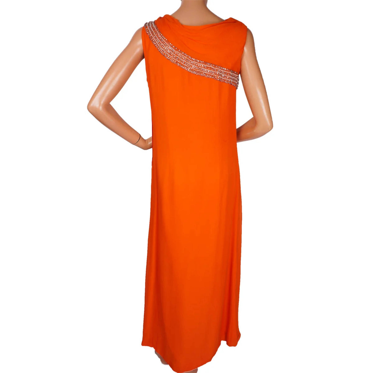 An orange sleeveless maxi dress with a draped neckline and a decorative silver beaded diagonal band across the upper chest, displayed on a female mannequin against a white background.