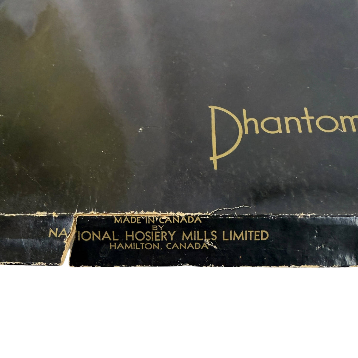 Close-up of a black nylon stocking box with gold lettering, showing the partial word 'Phantom' and text reading 'Made in Canada by National Hosiery Mills Limited, Hamilton, Canada.'.