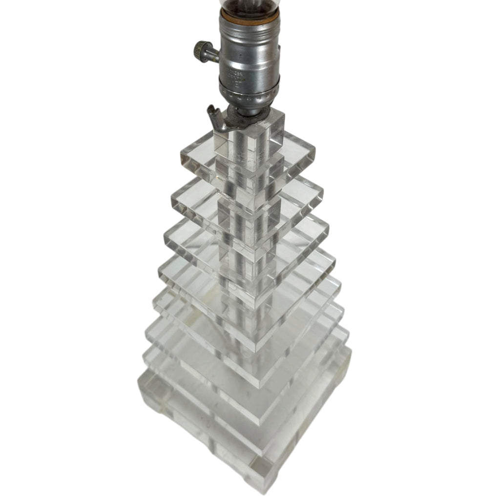 A clear lucite or acrylic geometric lamp base with a tiered, stacked pyramid design, topped with a vintage-style silver metal lamp socket.