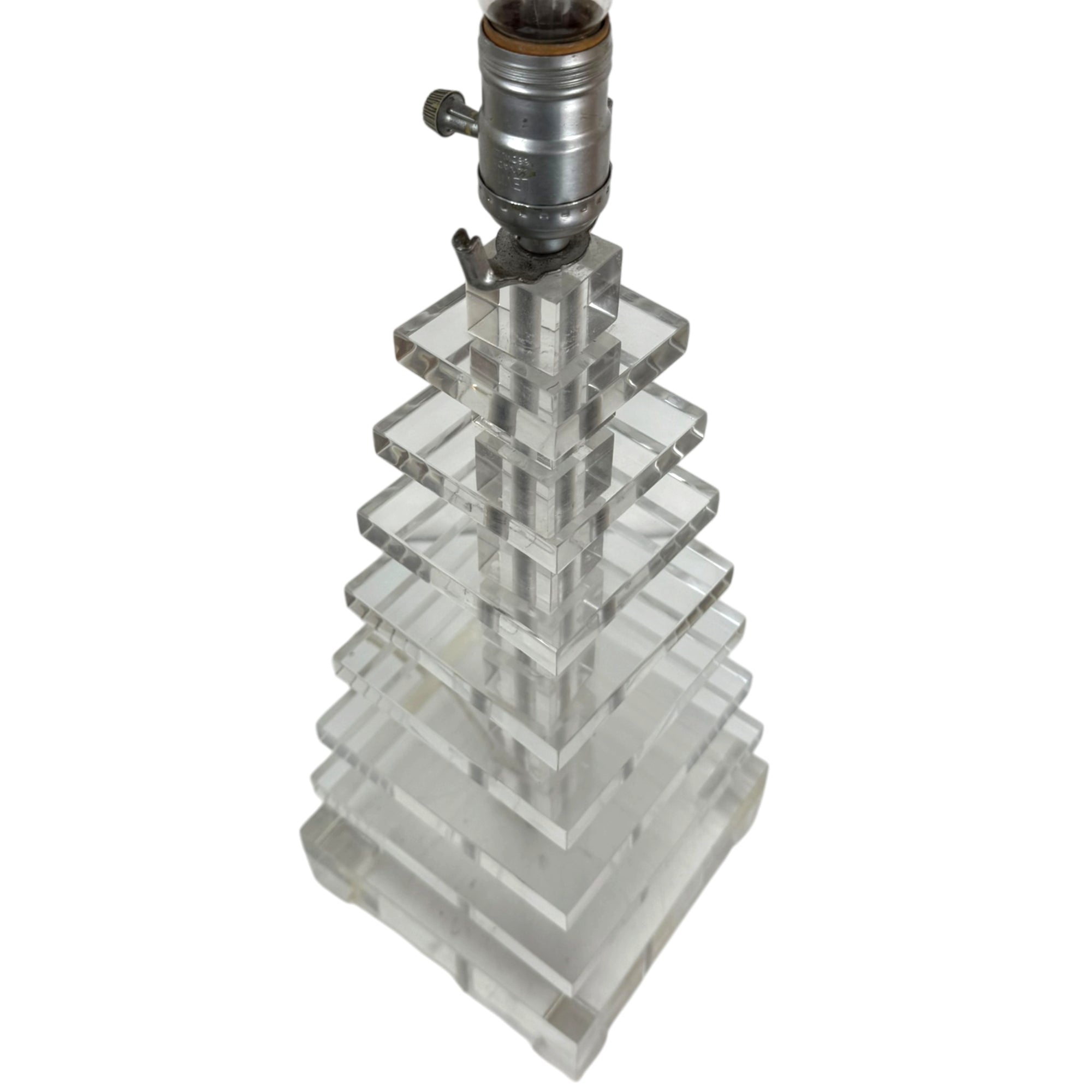 A clear lucite or acrylic geometric lamp base with a tiered, stacked pyramid design, topped with a vintage-style silver metal lamp socket.