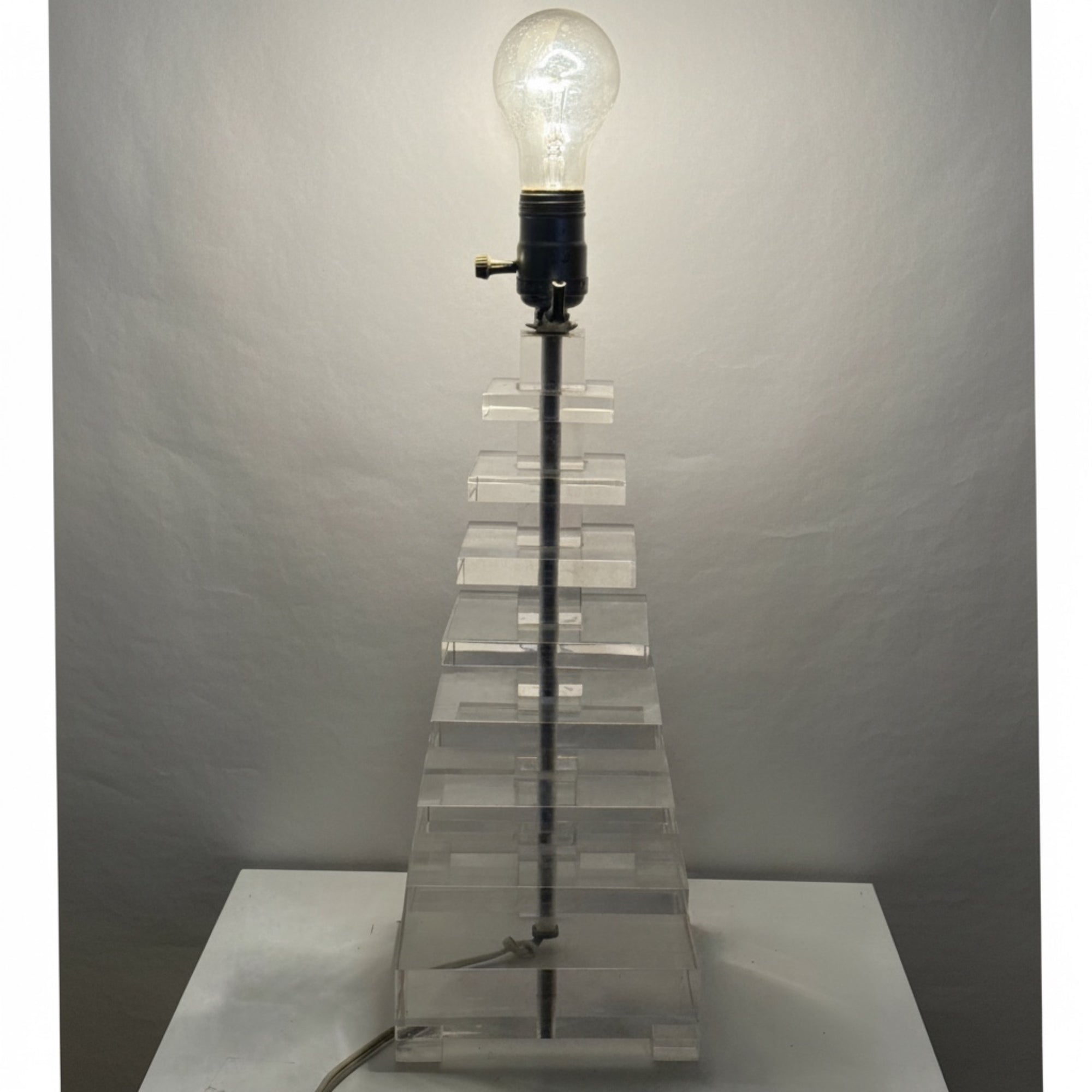 A lit stacked lucite table lamp 