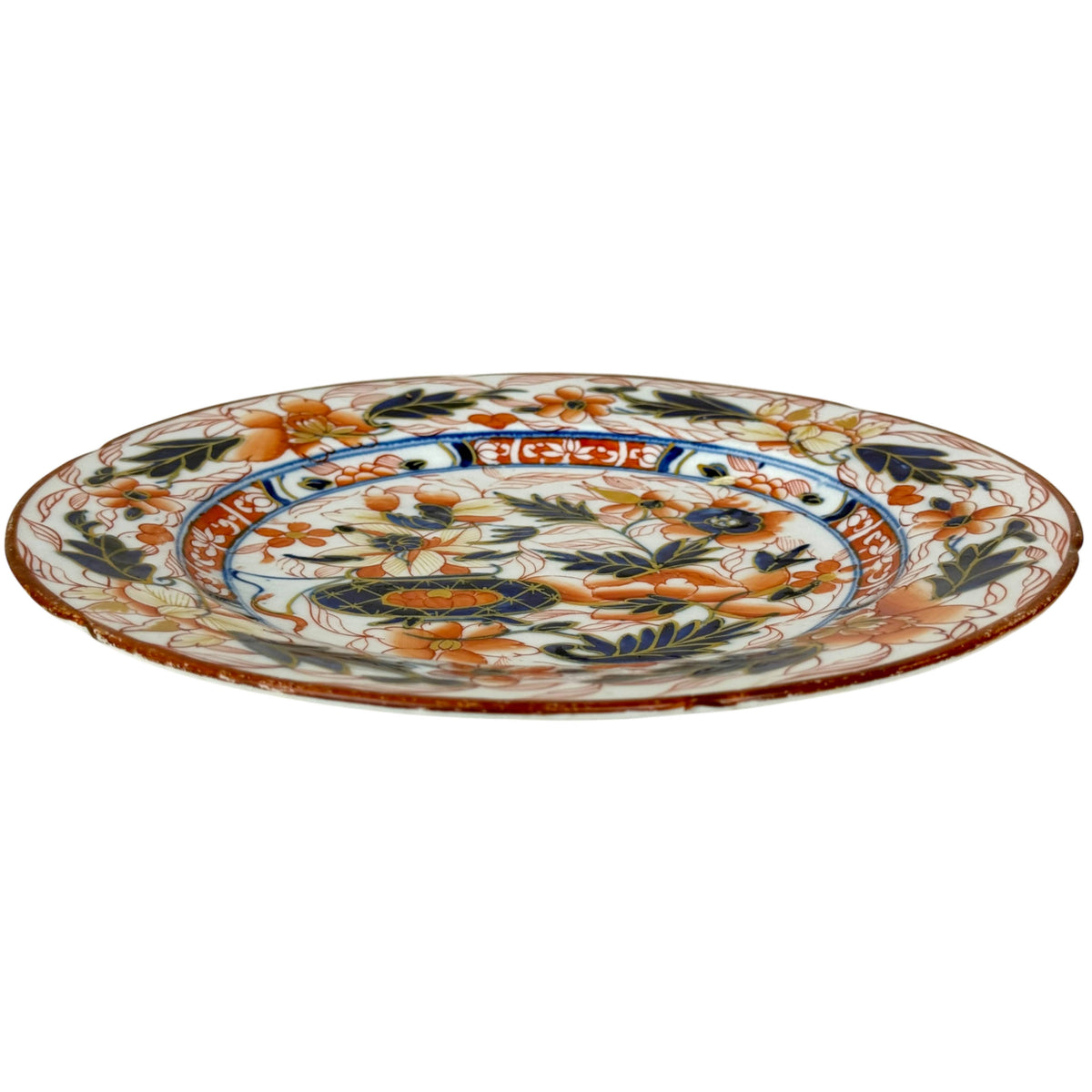 Side view of antique English Imari ironstone plate showing scalloped rim