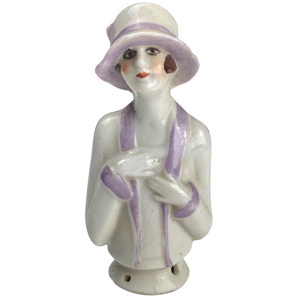 Antique 1920s German porcelain half-doll flapper girl wearing a lavender-trimmed cloche hat, front view