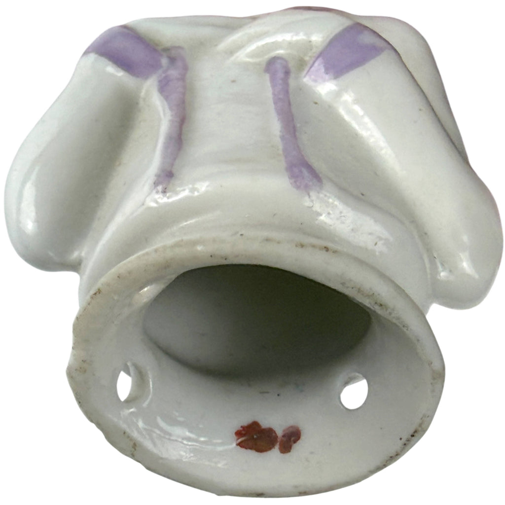 Underside of antique German porcelain half-doll showing hollow construction and sewing holes around the base