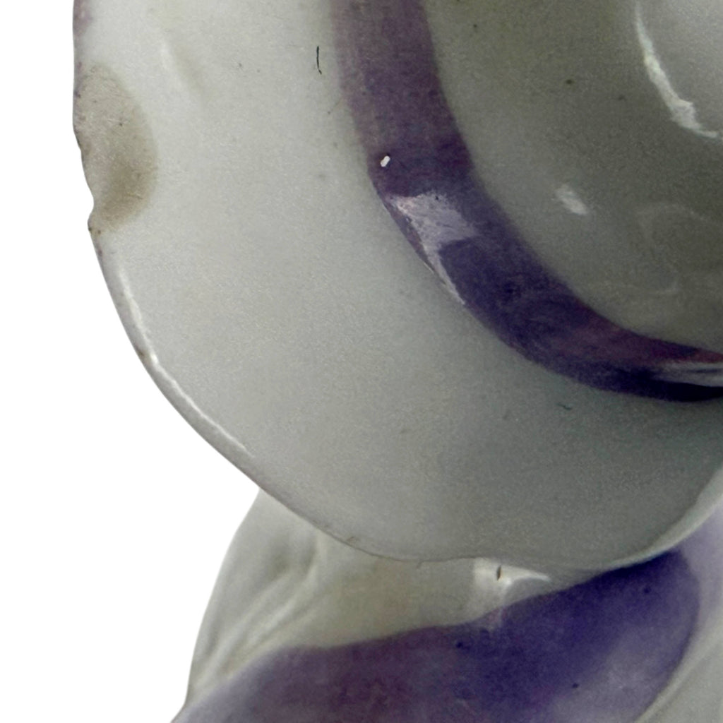 Close-up of small chip on the lavender-trimmed hat brim of the antique 1920s porcelain half-doll