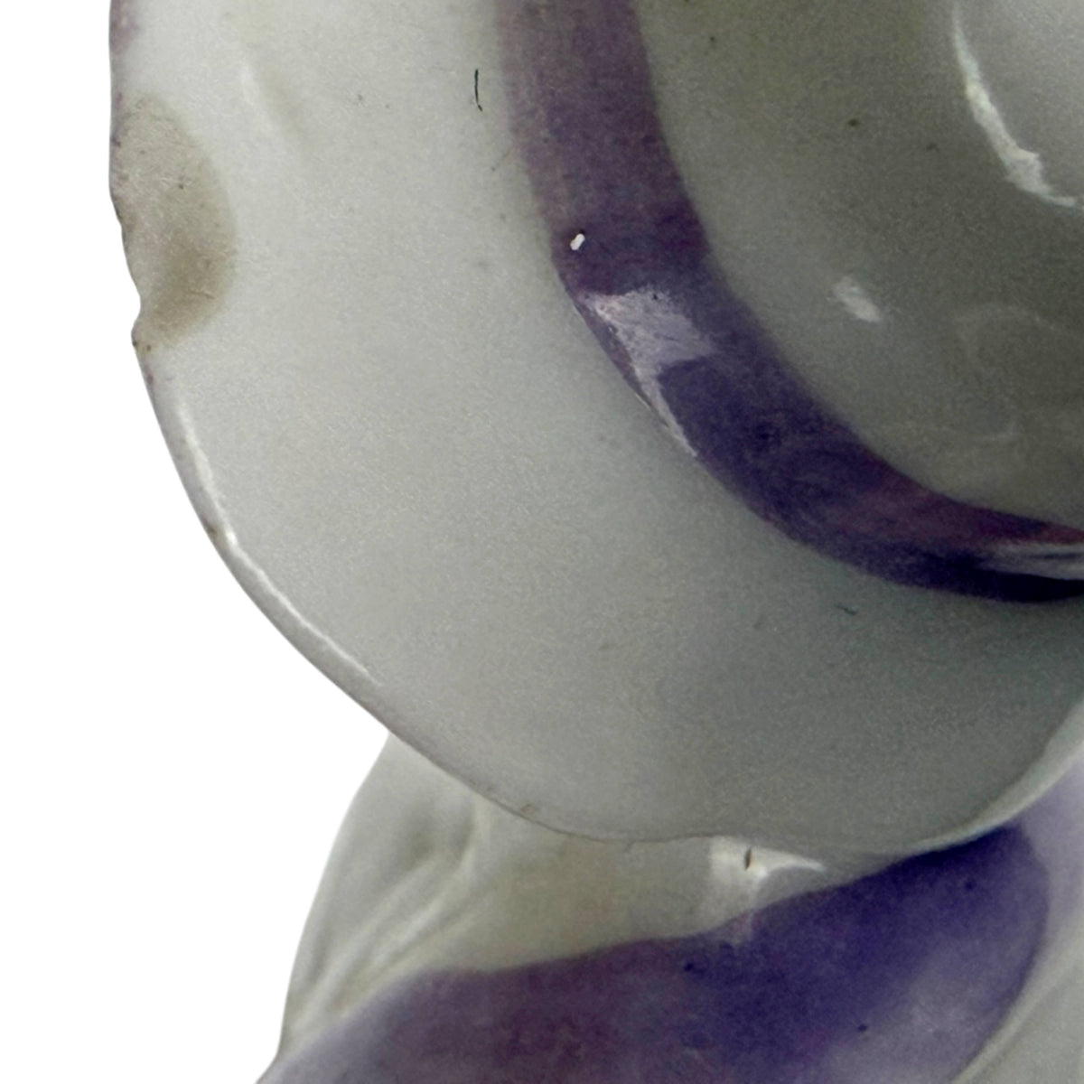 Close-up of small chip on the lavender-trimmed hat brim of the antique 1920s porcelain half-doll