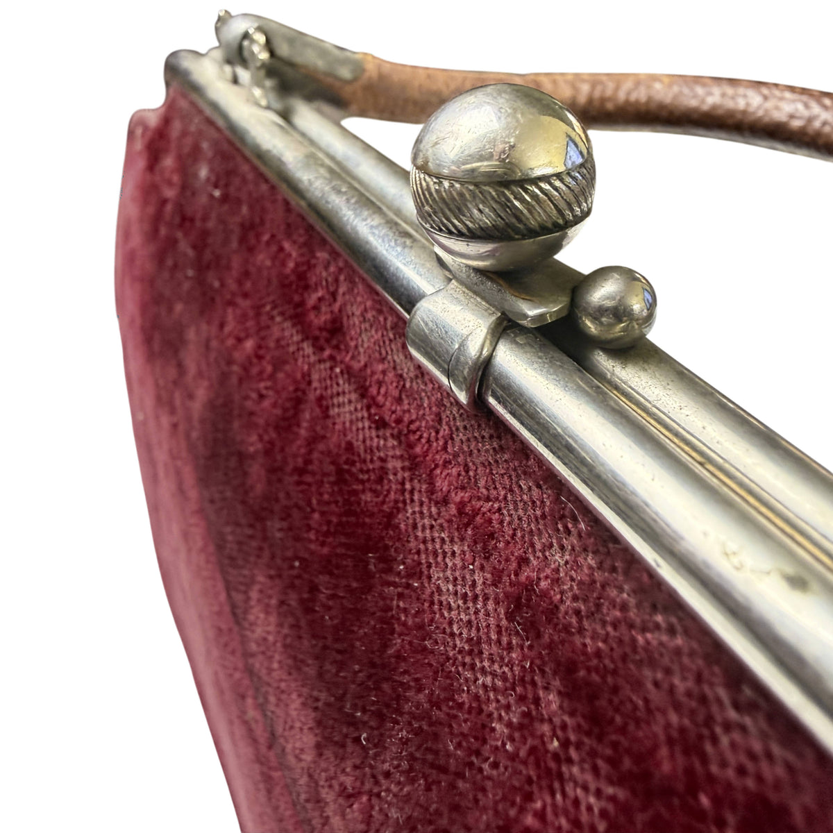 Close-up of Edwardian handbag's silver-coloured metal frame and decorative spherical kiss-lock clasp with ribbed centre band