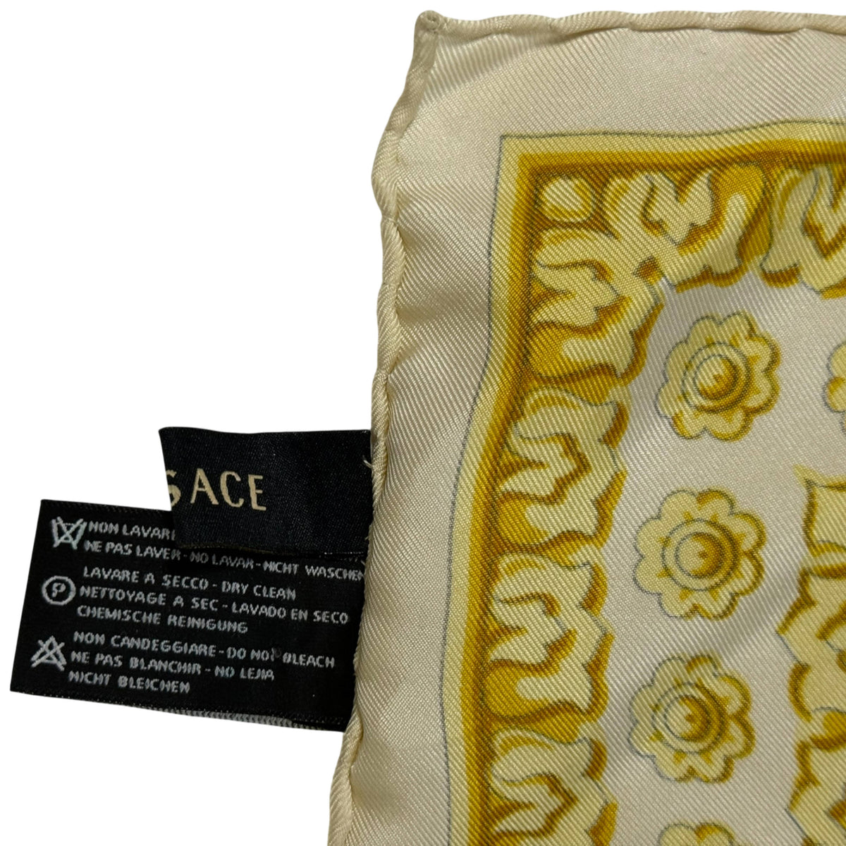 Reverse side of Atelier Versace silk scarf showing rolled stitched edge and original designer and care labels