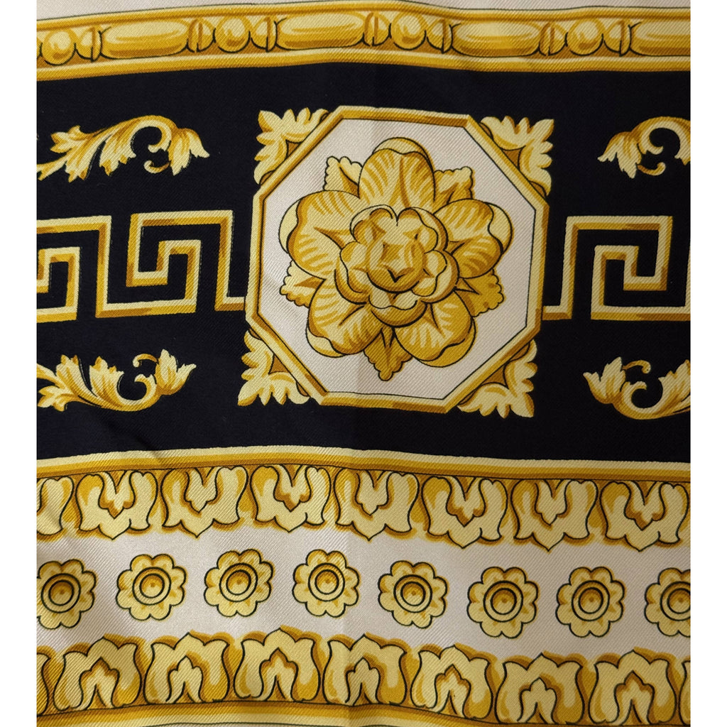 Detail of gold floral medallion and black Greek key border on Atelier Versace silk scarf