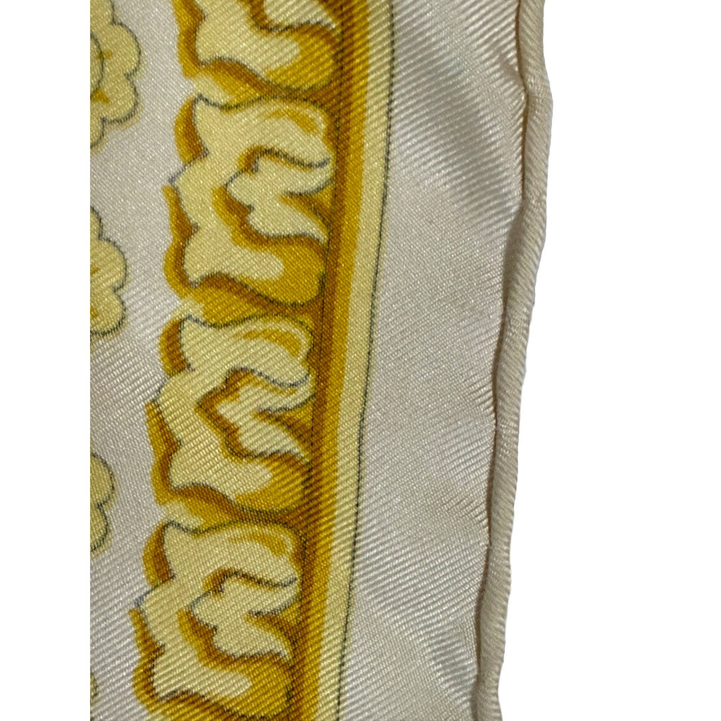 Close-up of hand-rolled stitched edge and gold patterned border of vintage Versace silk scarf