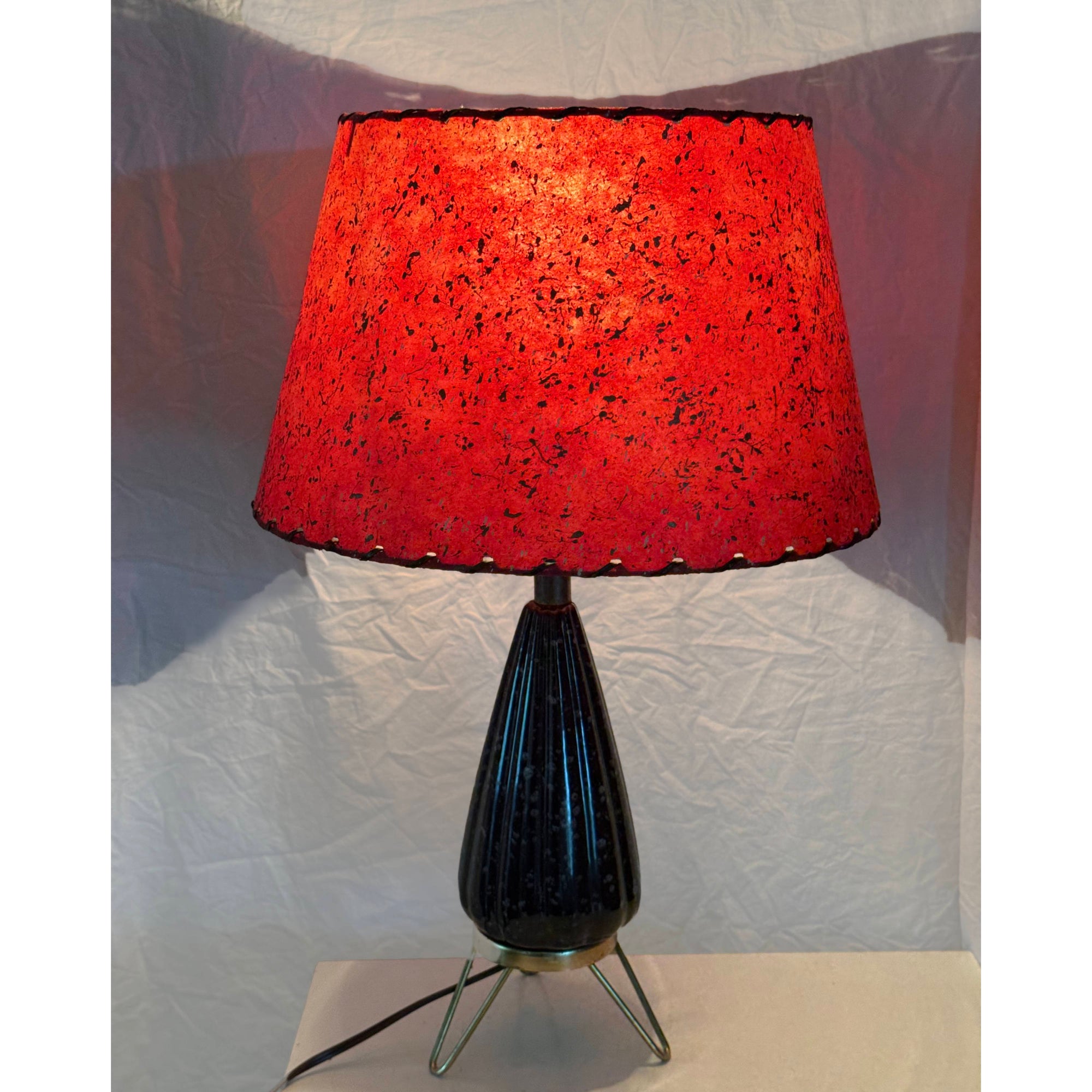 Vintage atomic table lamp illuminated with red fibreglass shade