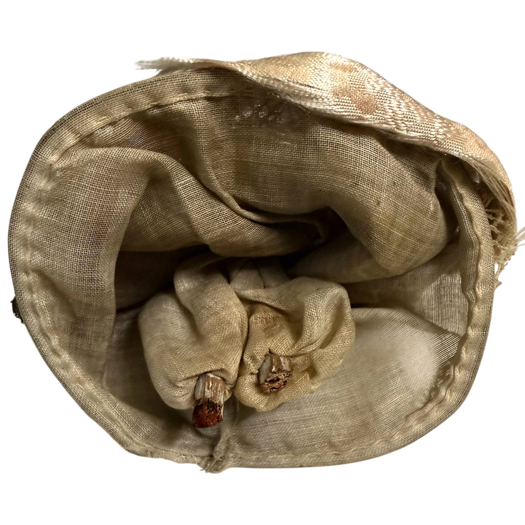 Underside of antique wooden peg doll showing cotton pantaloons and reinforced hem of silk ball gown