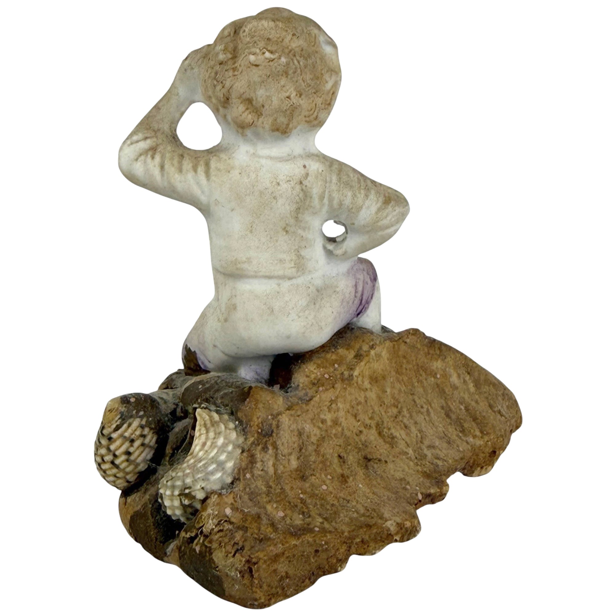 back of boy listening to seashell antique figurine