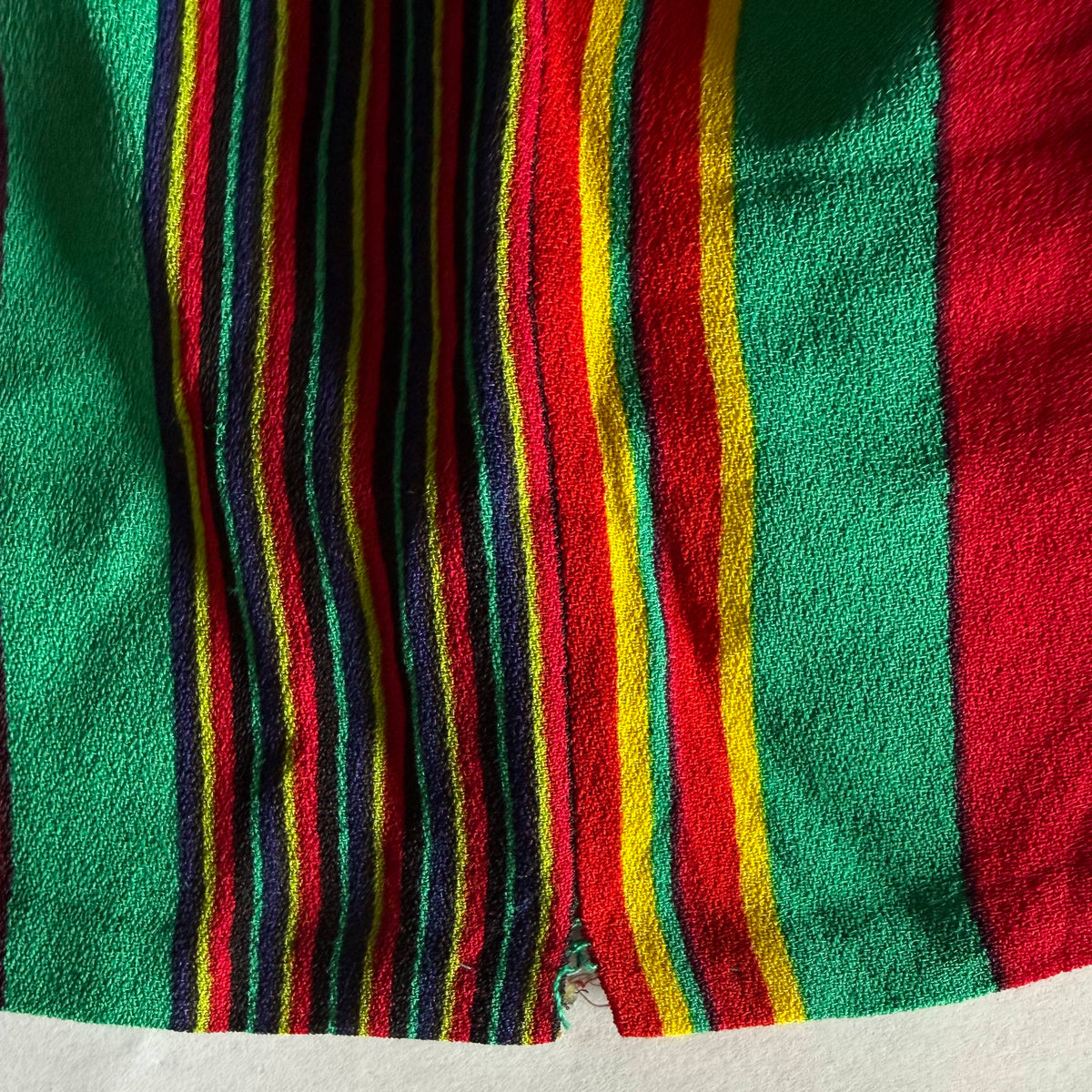 Close-up of small open side seam at hemline of vintage 1980s Céline Paris multicolour striped dress