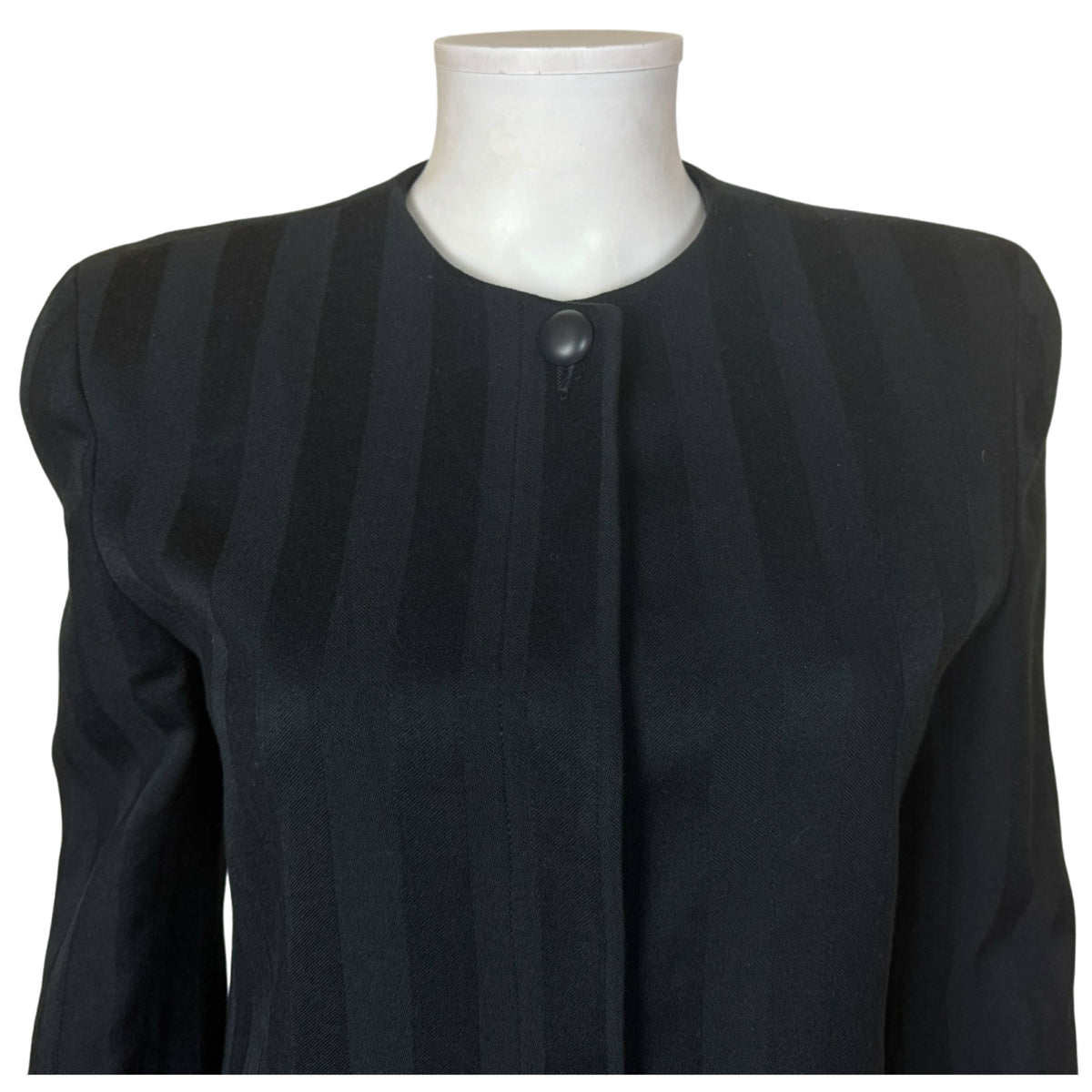 Close-up of Christian Dior collarless blazer showing rounded neckline, covered front placket and single black button