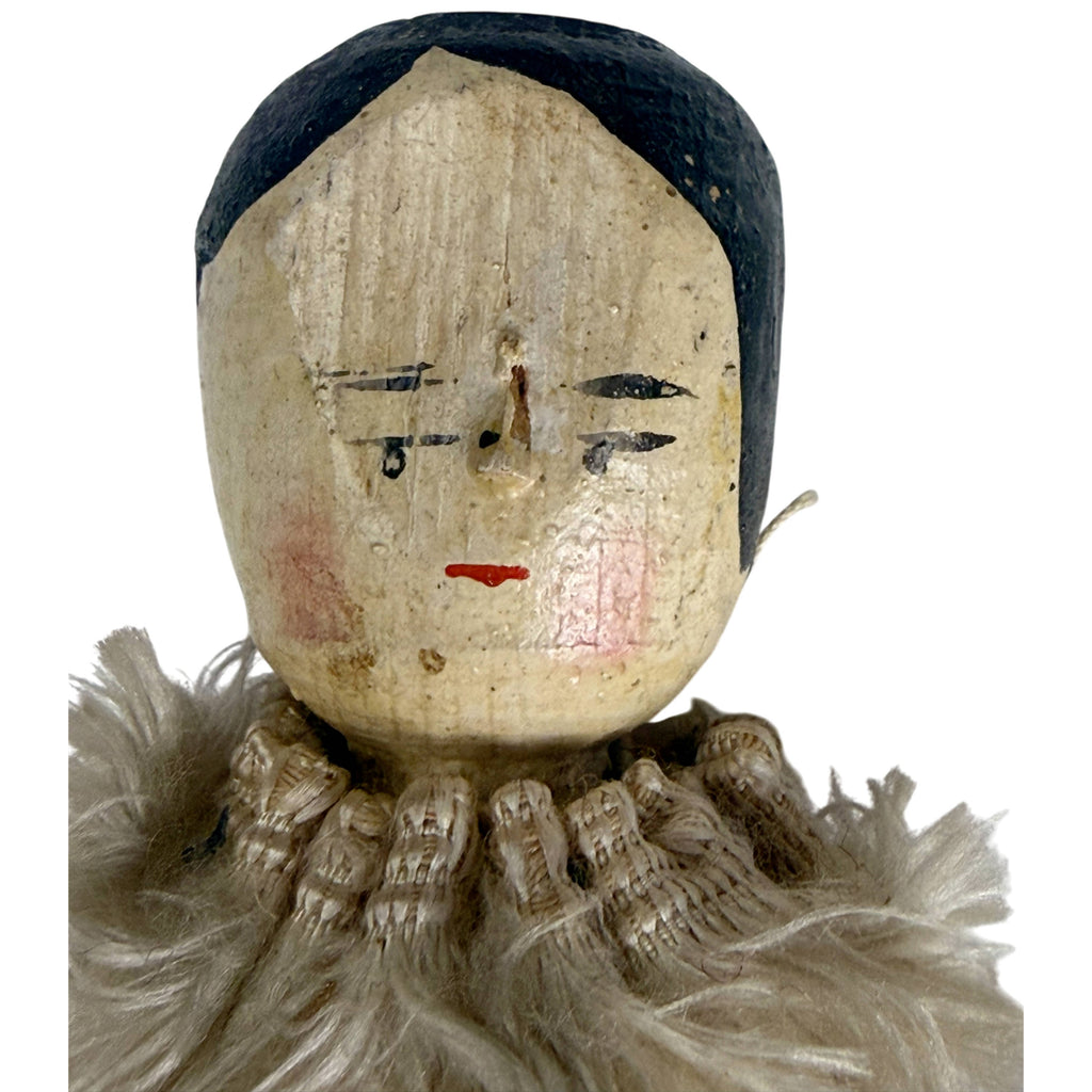 Detailed view of 19th-century German wooden doll face with black painted eyes, rosy cheeks and small red mouth