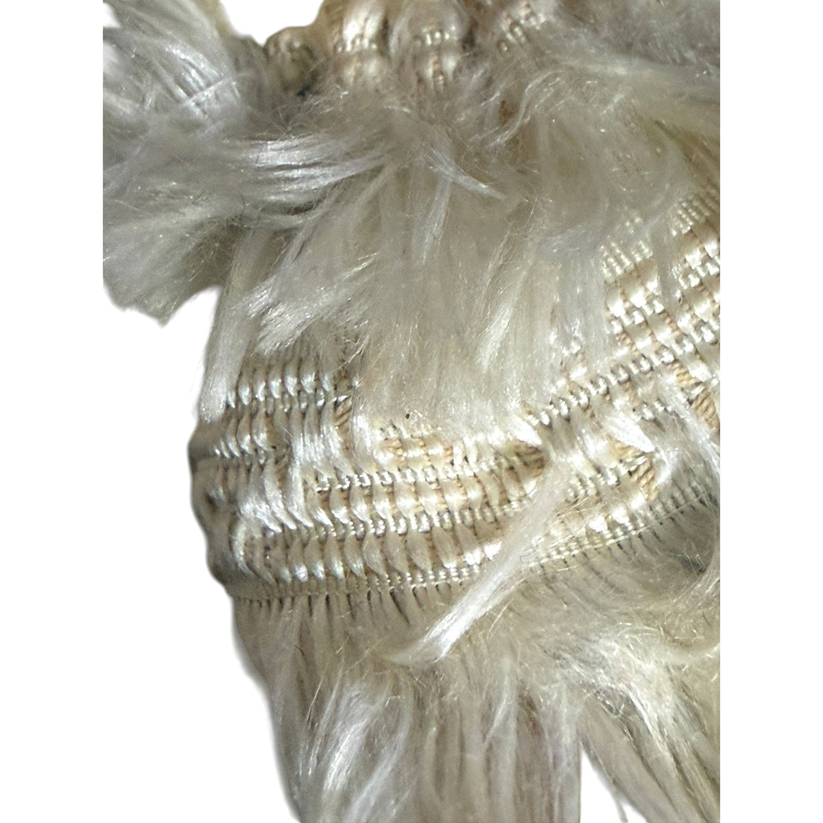 Close-up of antique cream silk passementerie showing decorative woven bands and long fringed silk fibres