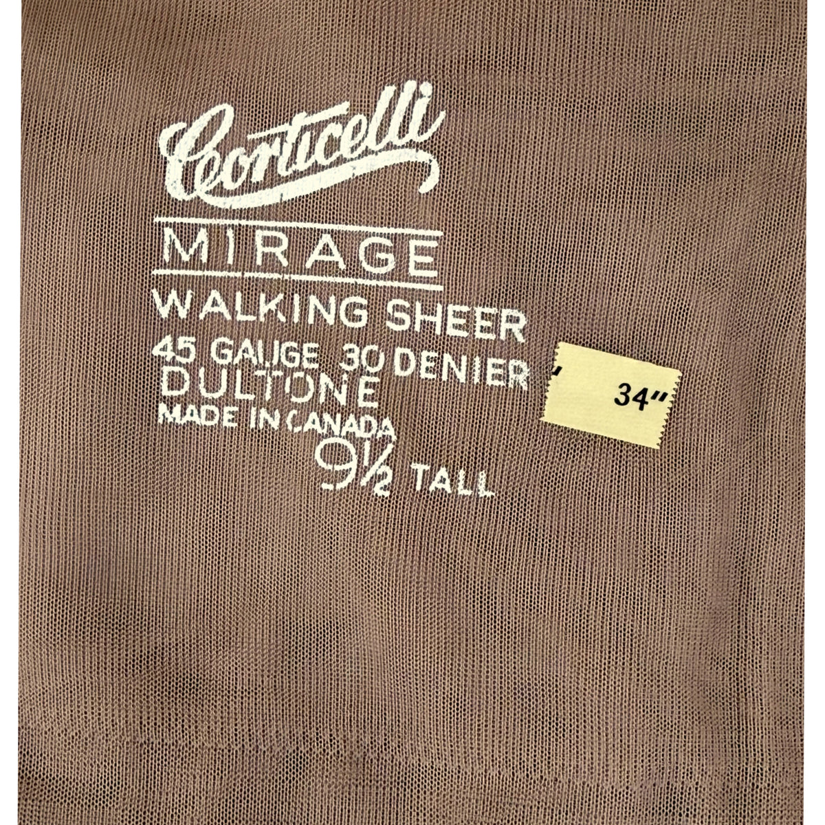 Close-up of a brown nylon stocking reading Corticelli Mirage Walking Sheer, 45 gauge 30 denier Dultone Made in Canada with a small yellow size sticker marked 34 inches.