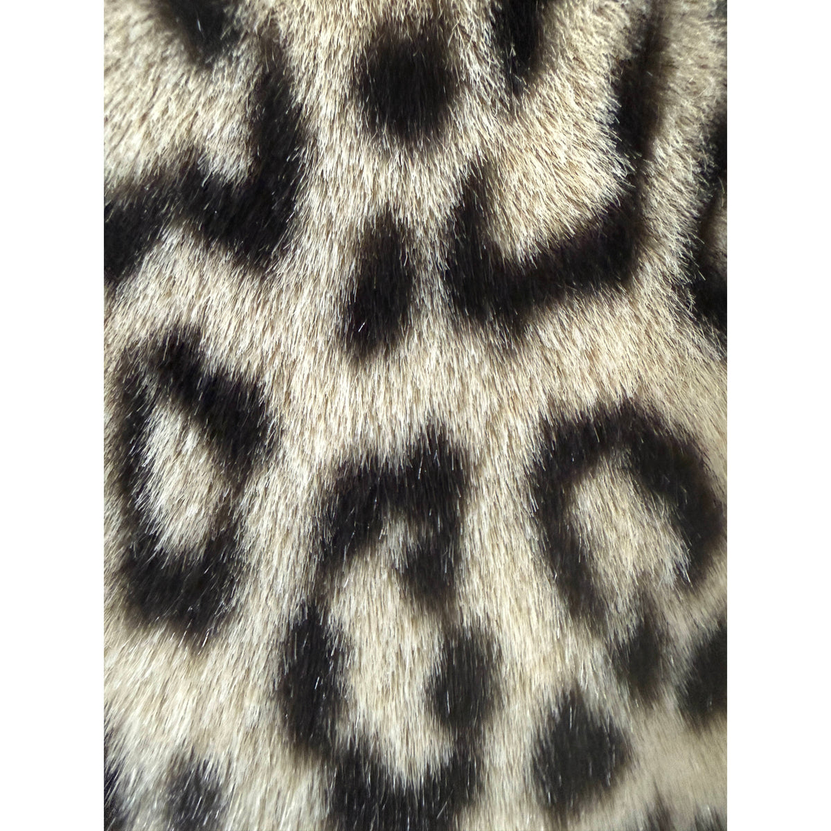 Close-up of dense French acrylic pile faux fur with realistic leopard markings and silky texture