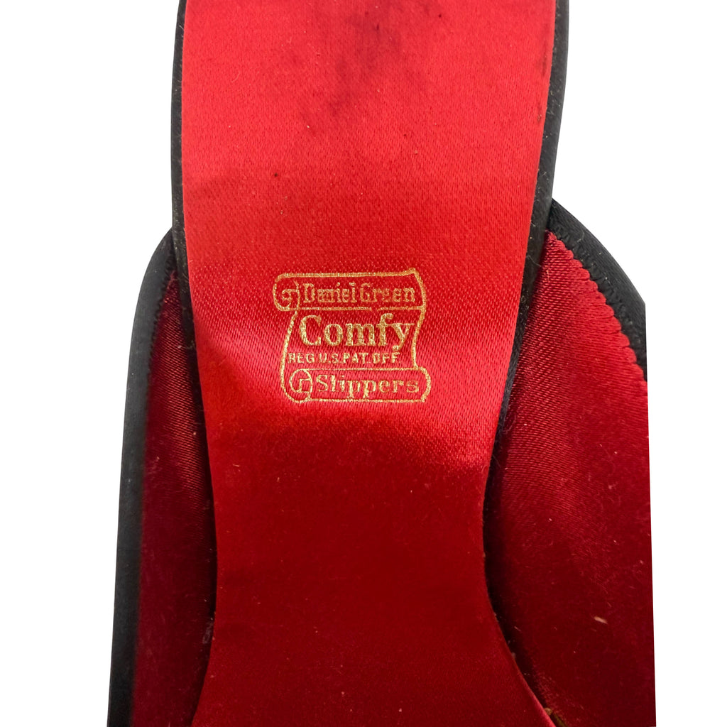 Close-up of the red insole of a Daniel Green Comfy Slippers, showing the brand logo in gold stamping