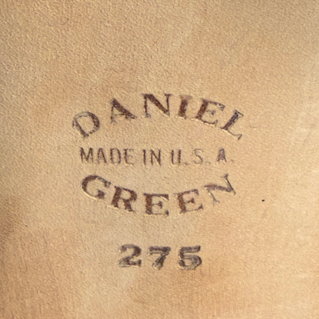 A close-up of slipper sole stamped with the text 'DANIEL GREEN MADE IN U.S.A. 275' 