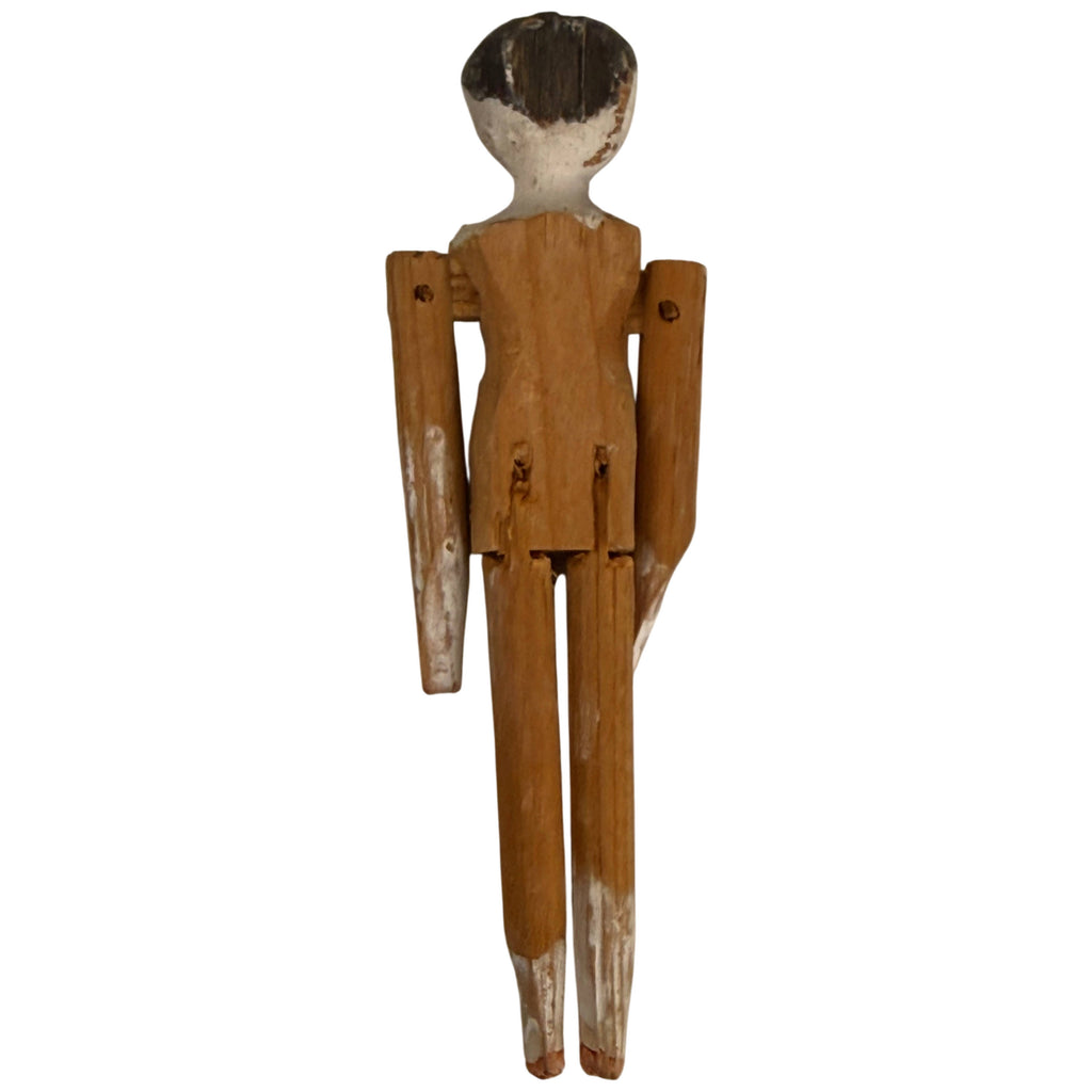 Rear view of antique German Grödnertal wooden peg doll showing natural wood torso, articulated limbs and remnants of white paint.