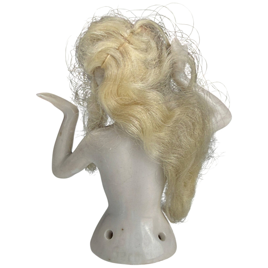 Back view of antique German porcelain half-doll showing long blonde wig, raised arms and sewing holes at base