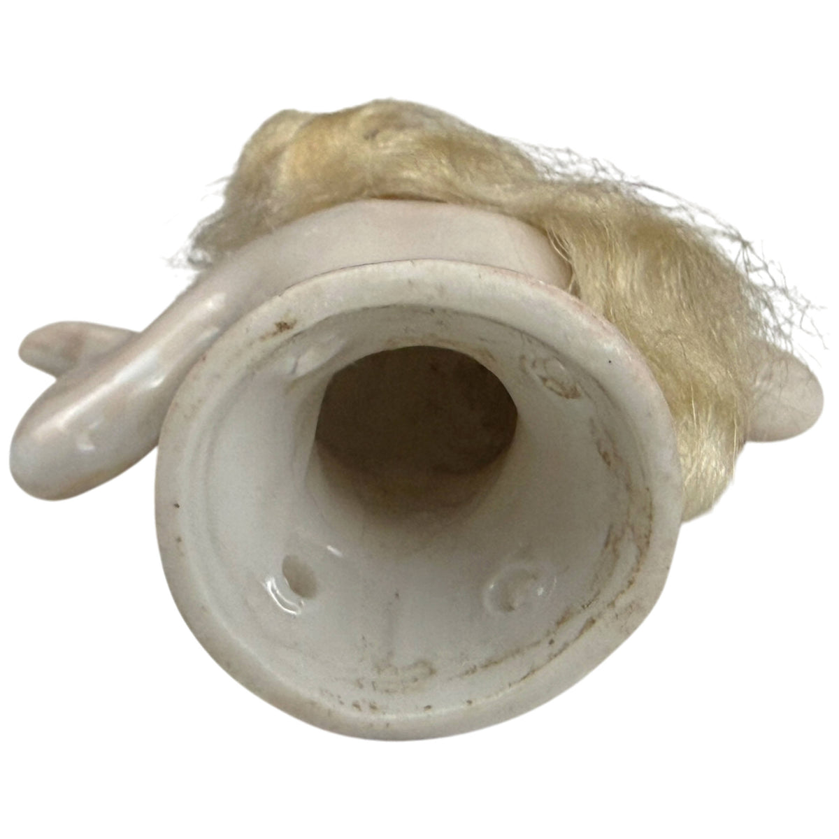 Underside of antique German porcelain half-doll showing hollow base and sewing holes