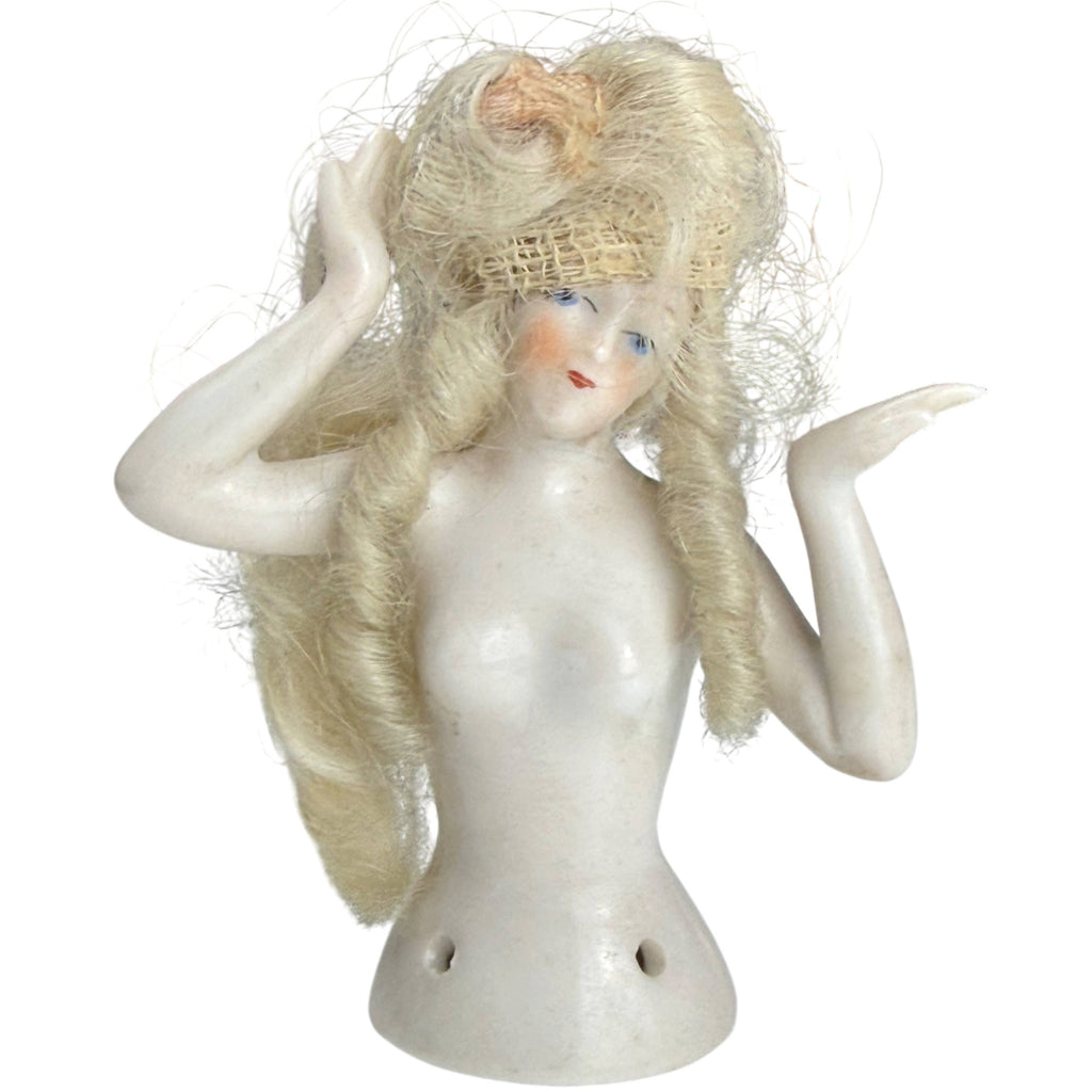 Antique German porcelain half-doll with blonde curled wig, blue eyes and raised hands-away pose, front view