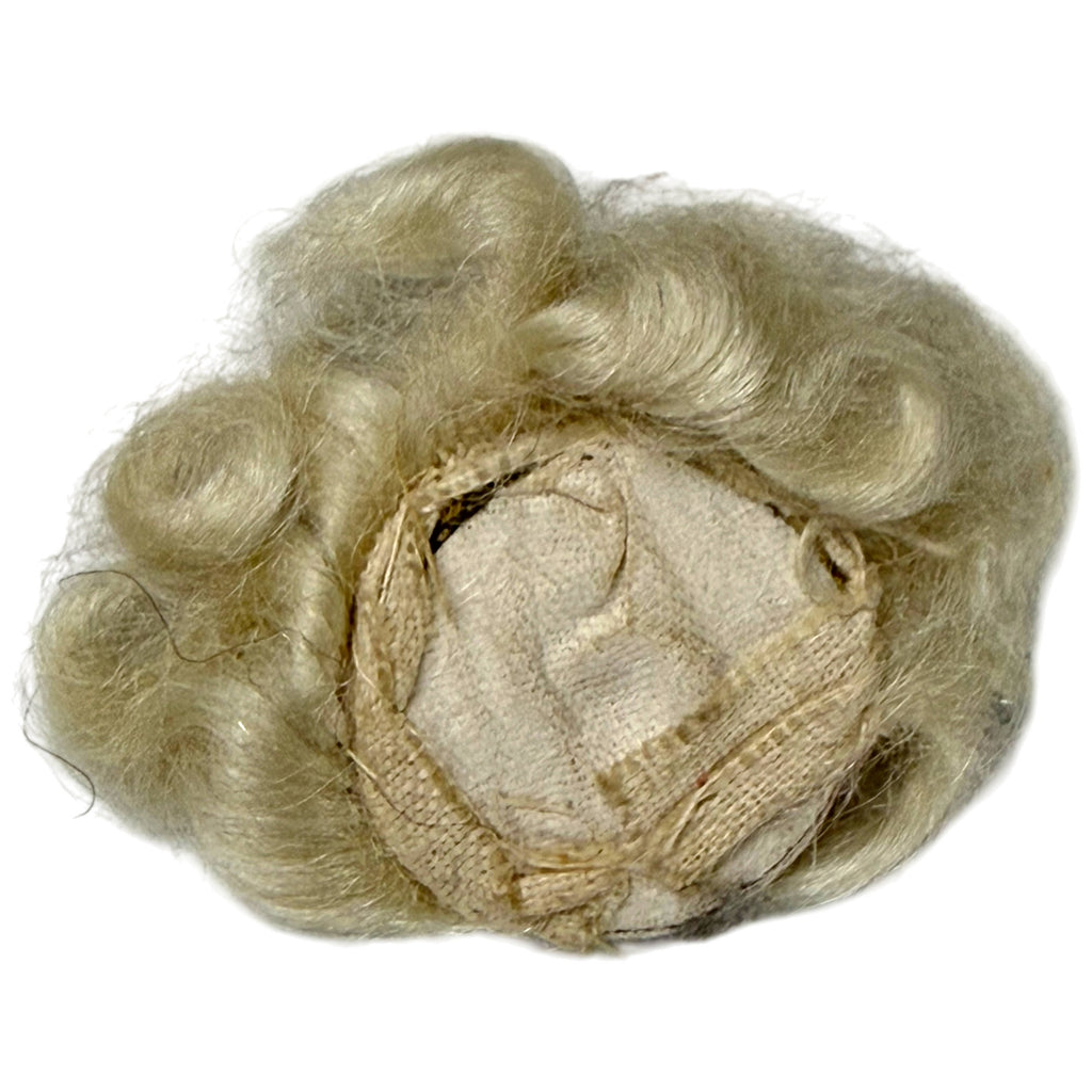 Reverse of antique Art Deco fabric face appliqué showing rigid fabric backing, original stitching and blonde wig construction