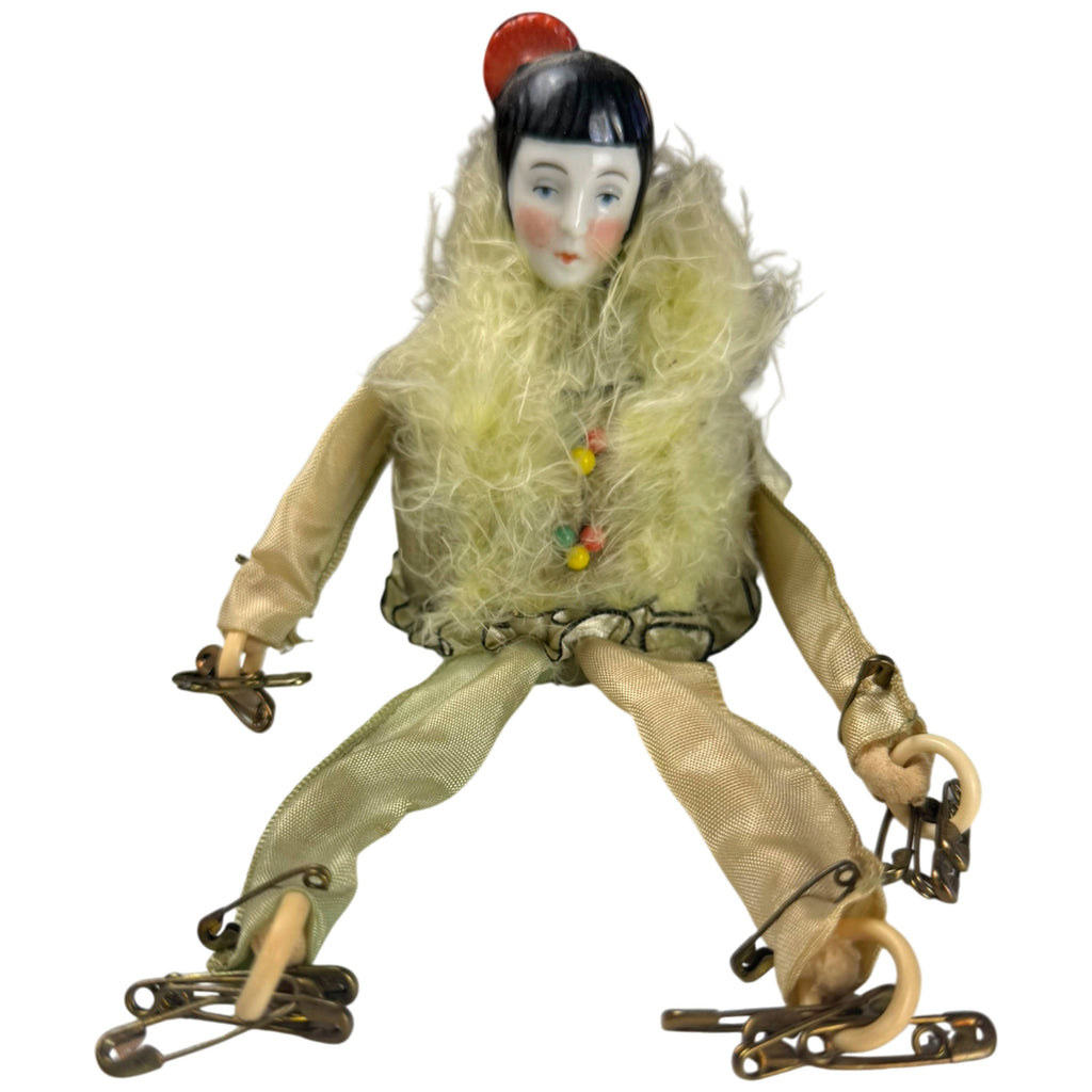 Full front view of antique Pierrot pincushion doll with feather-trimmed costume and long fabric limb