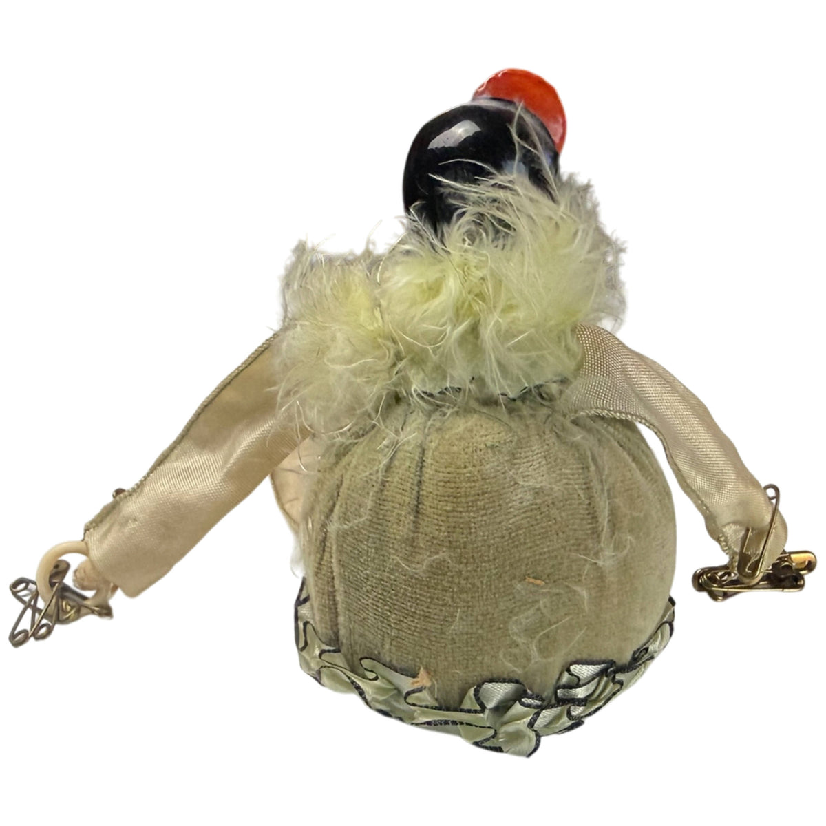 Back view of antique Pierrot half-doll pincushion showing rounded fabric body and feather collar