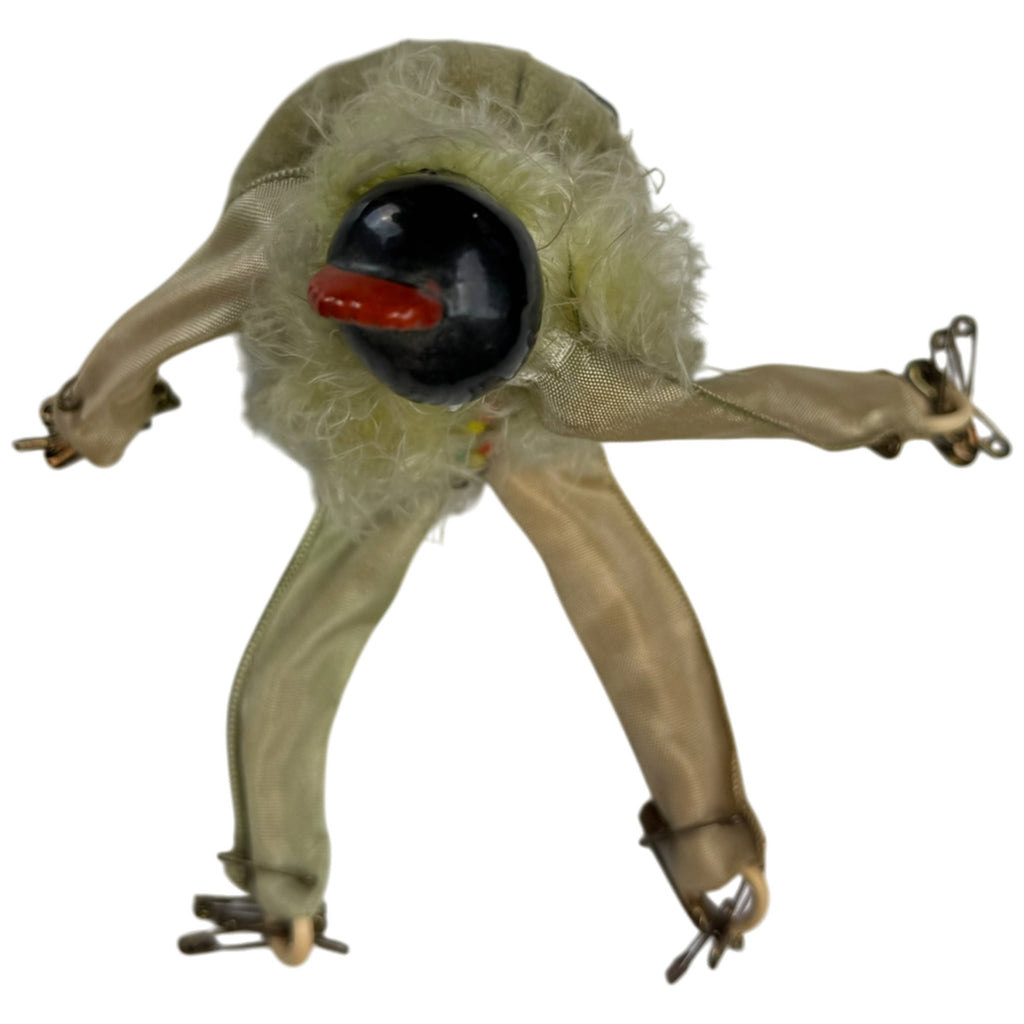 Overhead view of antique Pierrot doll showing black porcelain hair, red ornament and articulated limbs