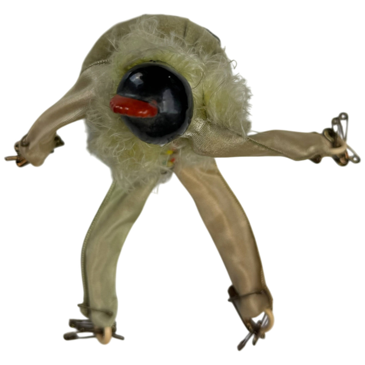 Overhead view of antique Pierrot doll showing black porcelain hair, red ornament and articulated limbs