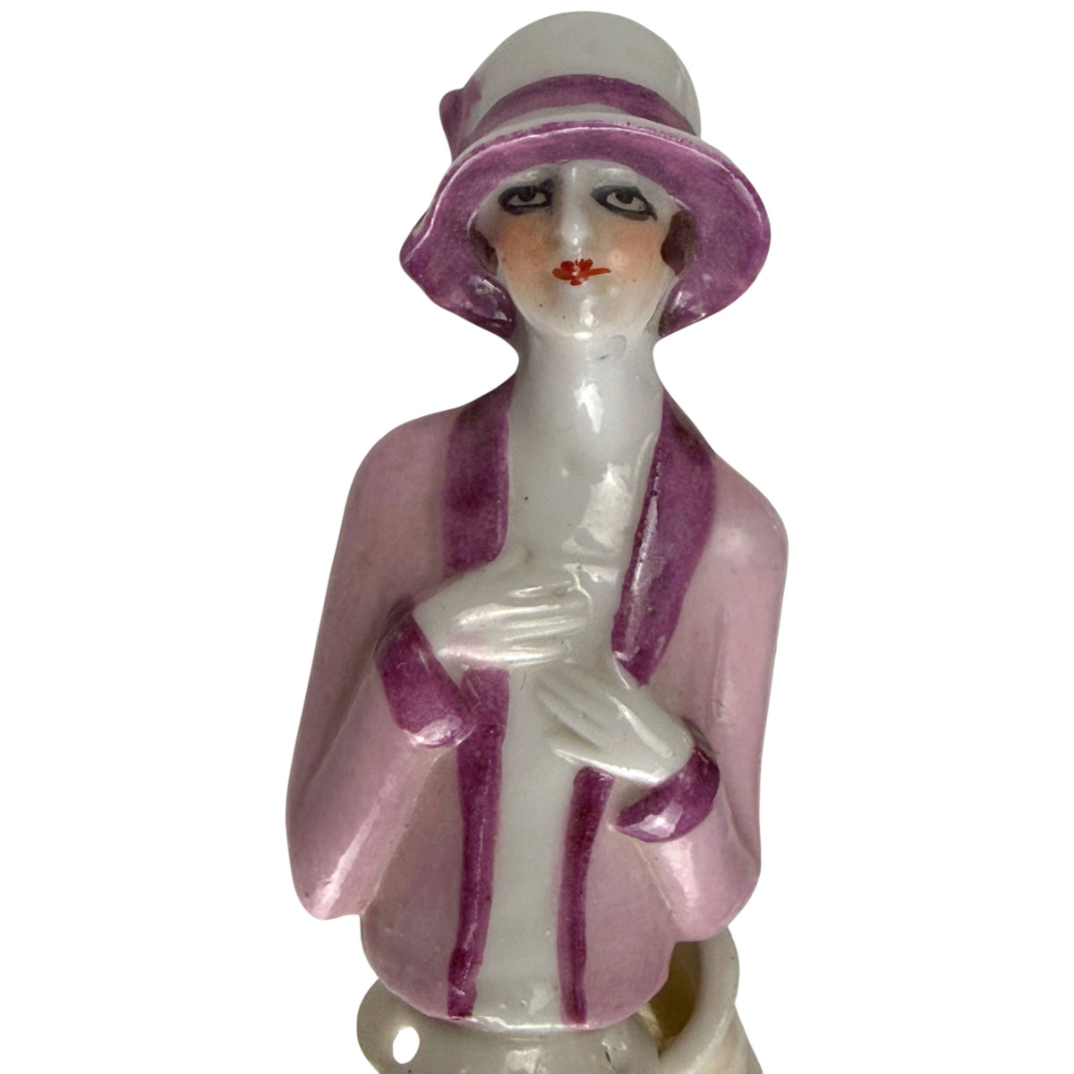 Close-up of antique Art Deco porcelain half doll showing purple cloche hat, pink jacket and delicately painted flapper face