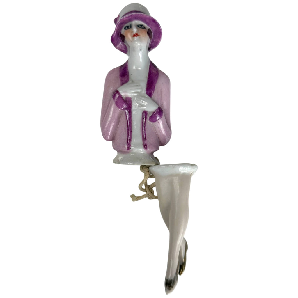 Antique 1920s German porcelain flapper half doll with matching legs, pink jacket, purple cloche hat and gold shoes, front view
