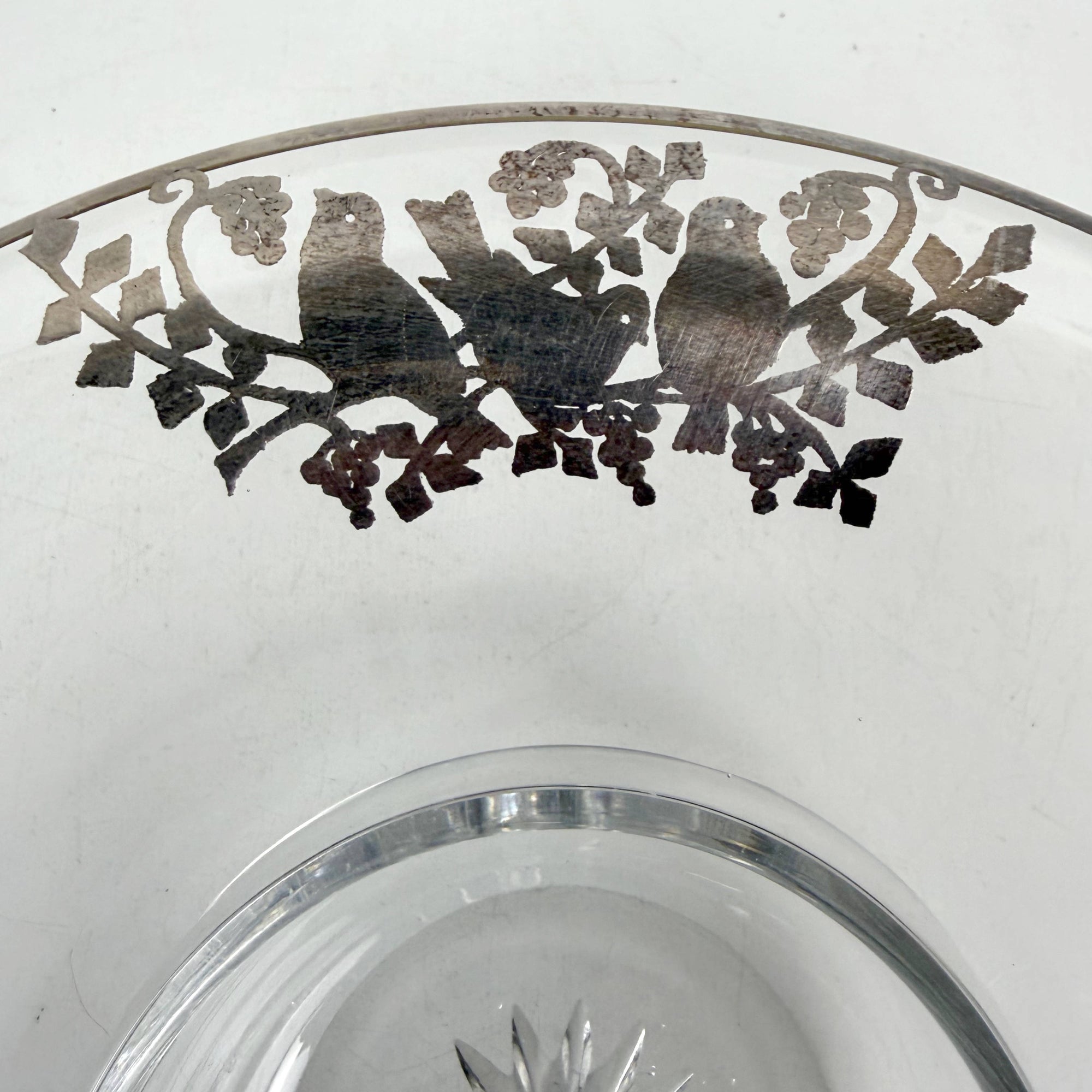 Close-up of silver overlay lovebirds on Heisey glass bowl rim