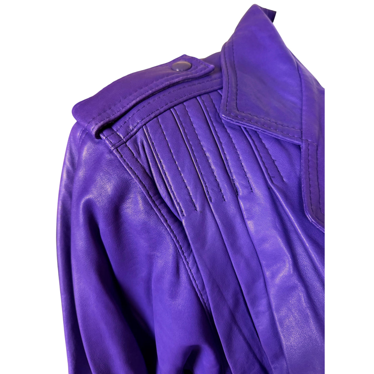 Close-up of shoulder epaulette with metal snap and decorative stitched pleating on purple leather