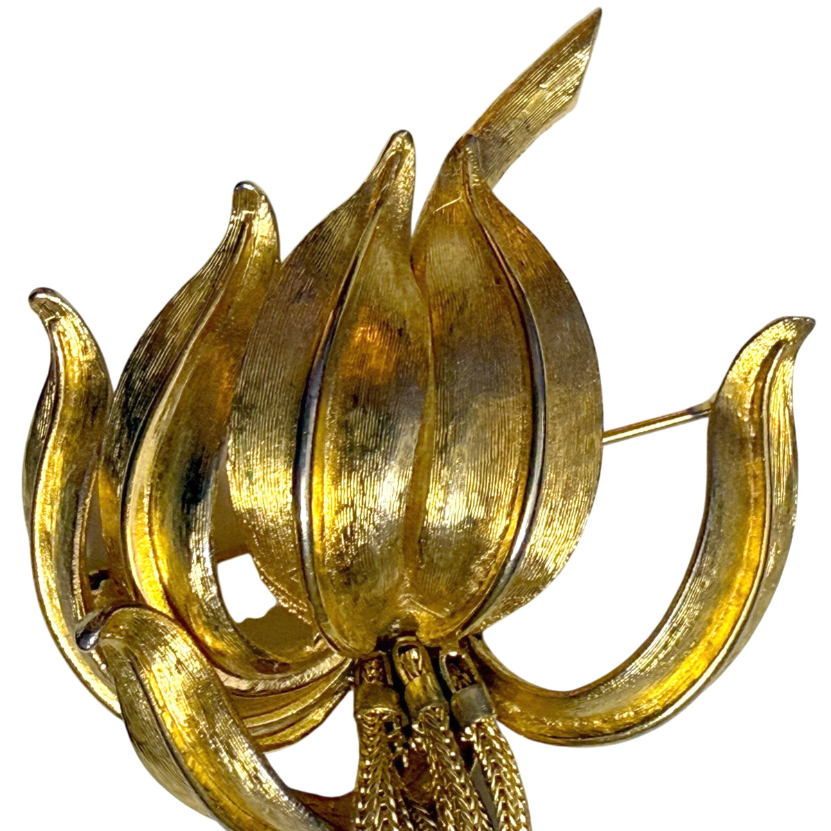 Close-up of textured gold-tone lily petals on vintage Kramer floral brooch