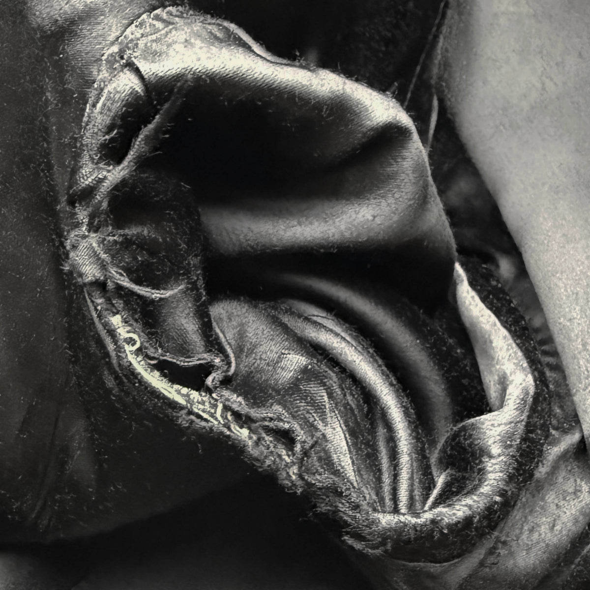 Close-up of open seam in black acetate lining at right armpit of vintage Cardinal wool overcoat