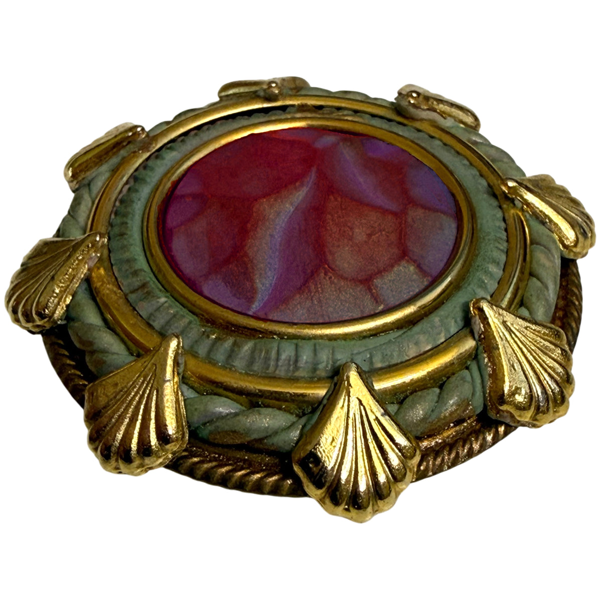Angled view of vintage mixed-media brooch with gold-tone shell decoration