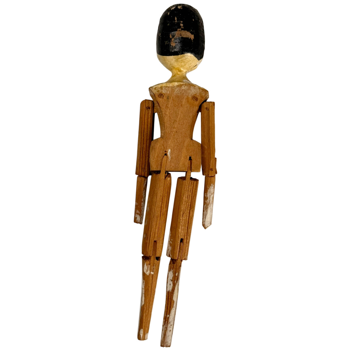 Rear view of antique German Grödnertal wooden peg doll showing carved torso, articulated limbs and worn black painted hair.