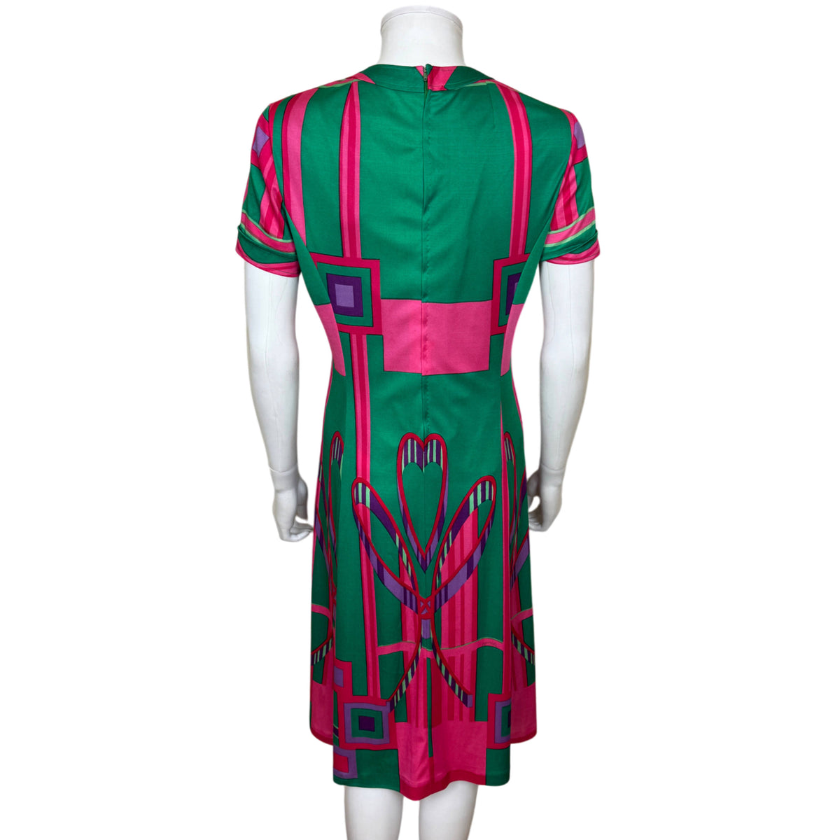Back of vintage Montreux Knitting Swiss jersey dress showing centre back zipper and geometric pink and green print