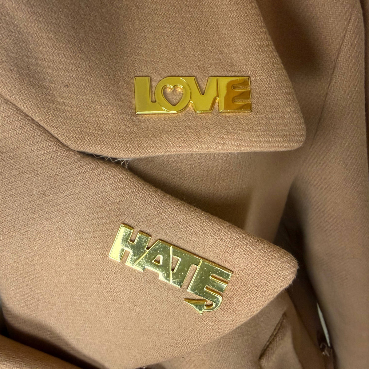 close up of Moschino Love and Hate lapel pins