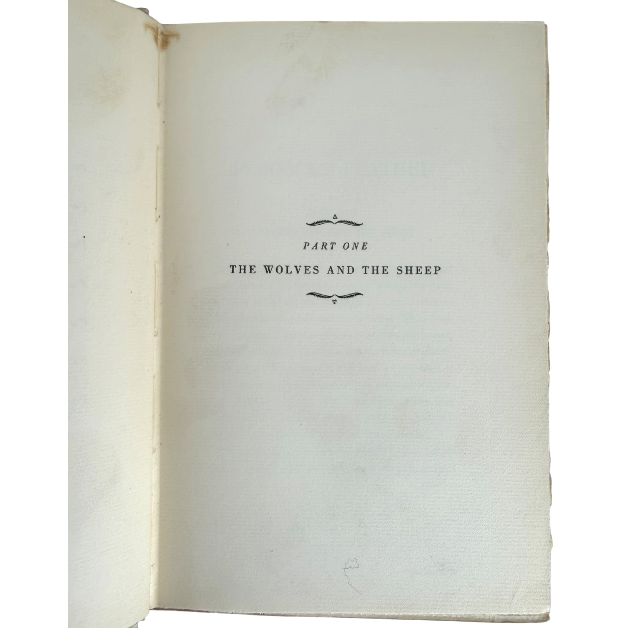 An open vintage book showing the title page for 'Part One: The Wolves and the Sheep' in black serif text on aged, off-white paper.